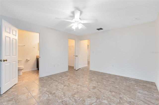 unfurnished bedroom featuring ceiling fan, connected bathroom, a closet, and a walk in closet