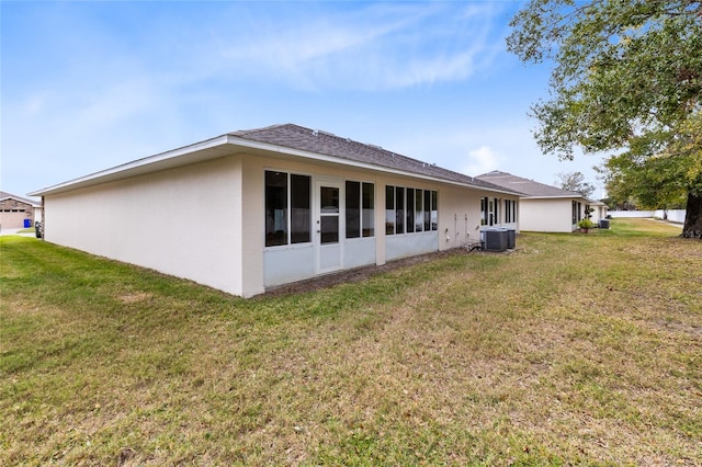 back of house with a lawn and central AC