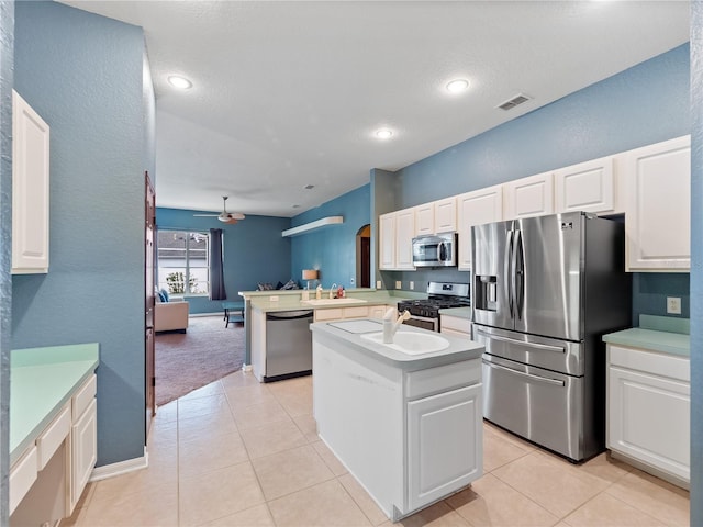 kitchen with ceiling fan, a kitchen island, kitchen peninsula, appliances with stainless steel finishes, and white cabinets