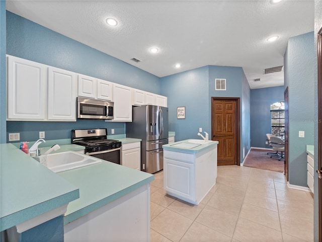 kitchen with sink, white cabinets, stainless steel appliances, and light tile patterned flooring