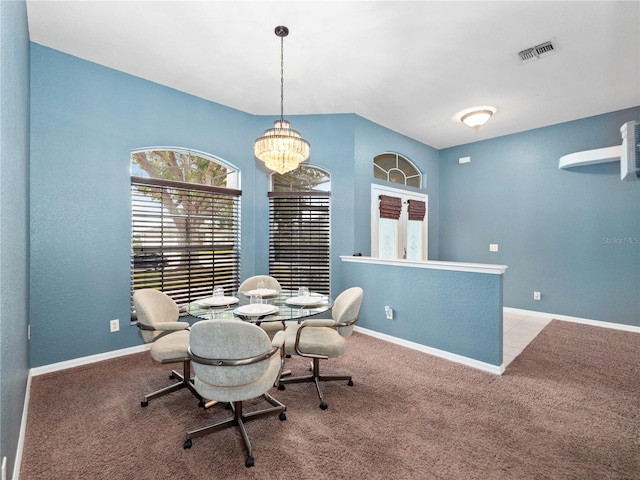 carpeted dining area featuring an inviting chandelier