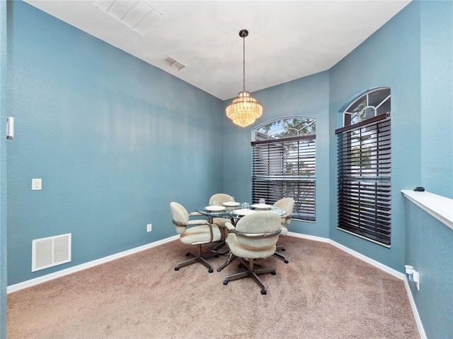 dining space with carpet floors and a chandelier