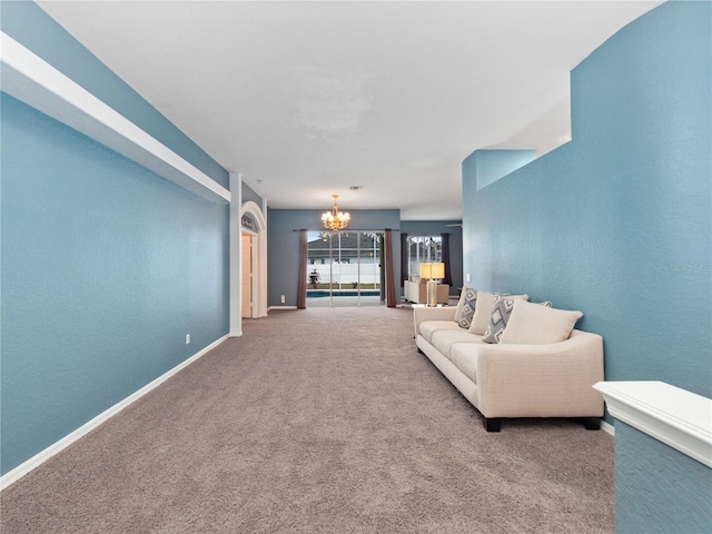 carpeted living room featuring a notable chandelier