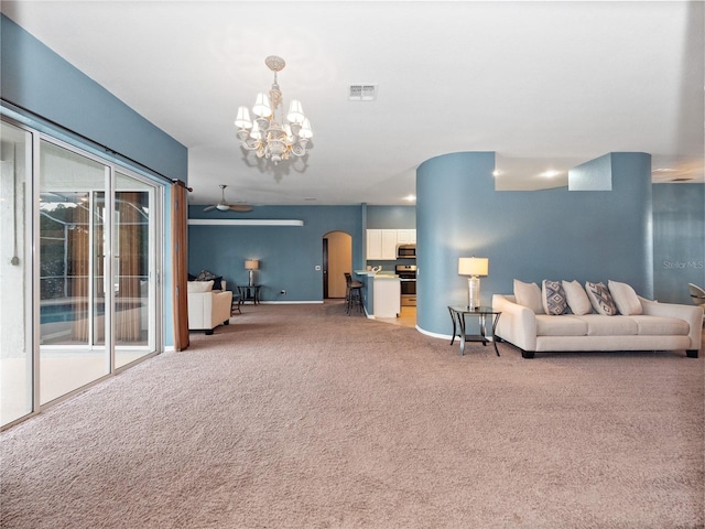 unfurnished living room with ceiling fan with notable chandelier and carpet floors