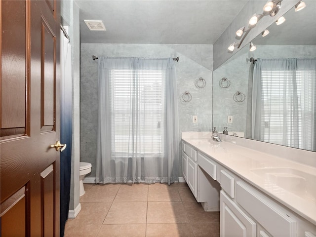 bathroom with toilet, vanity, and tile patterned floors