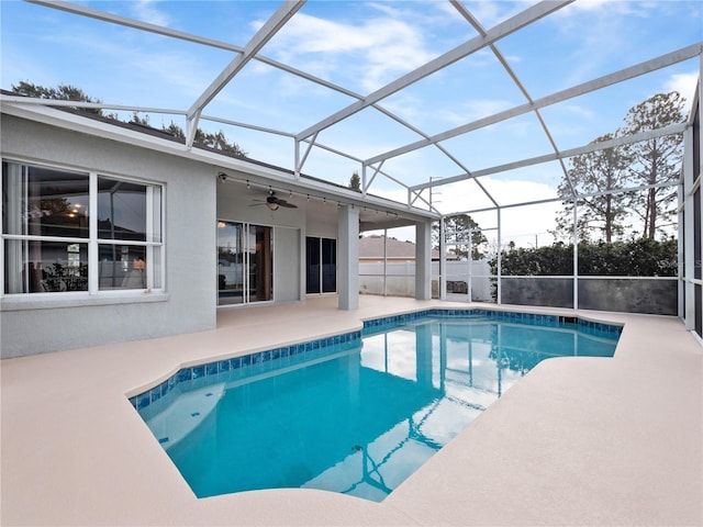 view of swimming pool featuring a lanai, ceiling fan, and a patio