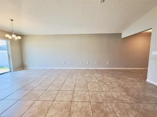 505 Pentas Ln, Haines City, FL 33844 - empty room with light tile patterned floors, a chandelier, a textured ceiling, and baseboards