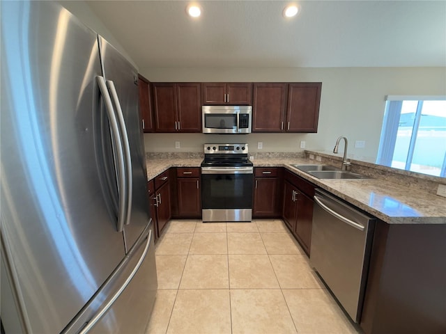 505 Pentas Ln, Haines City, FL 33844 - kitchen featuring appliances with stainless steel finishes, a sink, dark brown cabinetry, a peninsula, and light tile patterned floors