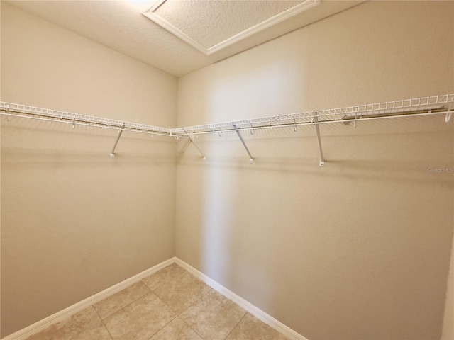 505 Pentas Ln, Haines City, FL 33844 - spacious closet with light tile patterned floors and attic access