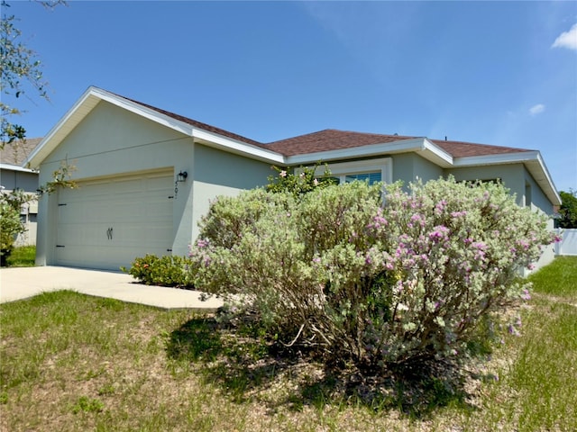 505 Pentas Ln, Haines City, FL 33844 - view of front facade featuring stucco siding, a garage, and concrete driveway