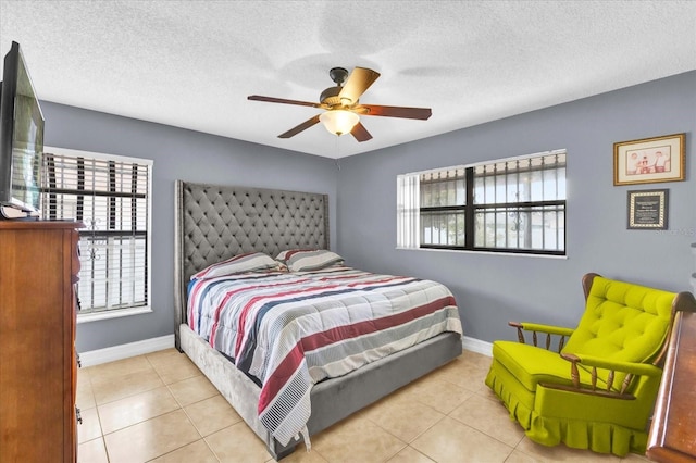 tiled bedroom with multiple windows, ceiling fan, and a textured ceiling