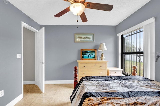 tiled bedroom with ceiling fan and a textured ceiling