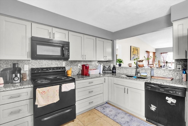 kitchen with sink, light tile patterned floors, tasteful backsplash, light stone counters, and black appliances