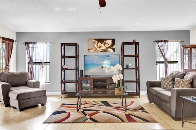 living room featuring light tile patterned floors, a textured ceiling, and ceiling fan