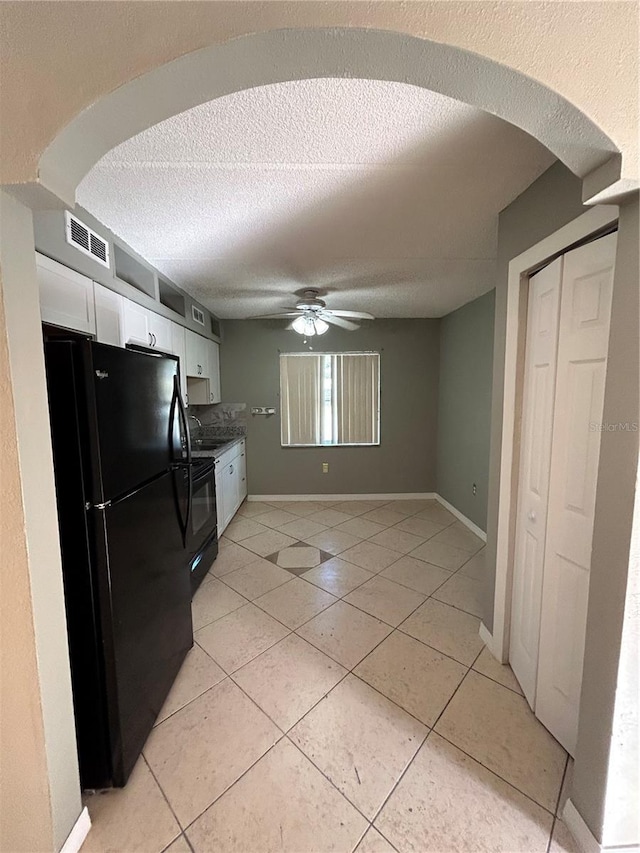 kitchen featuring light tile patterned floors, white cabinetry, ceiling fan, and black appliances