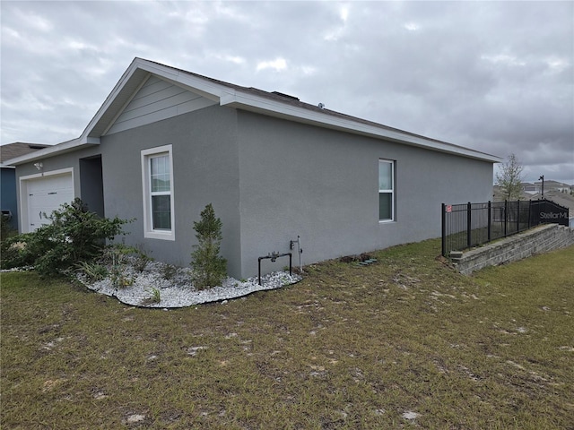 view of side of property with a lawn and a garage