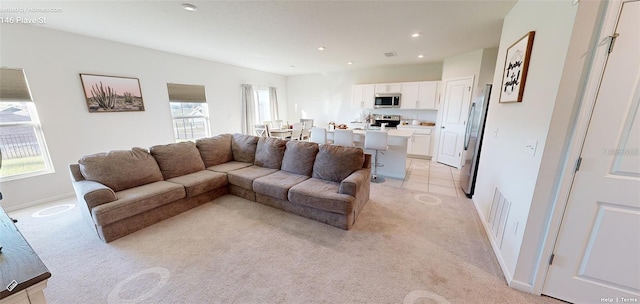 living room featuring light colored carpet and a healthy amount of sunlight