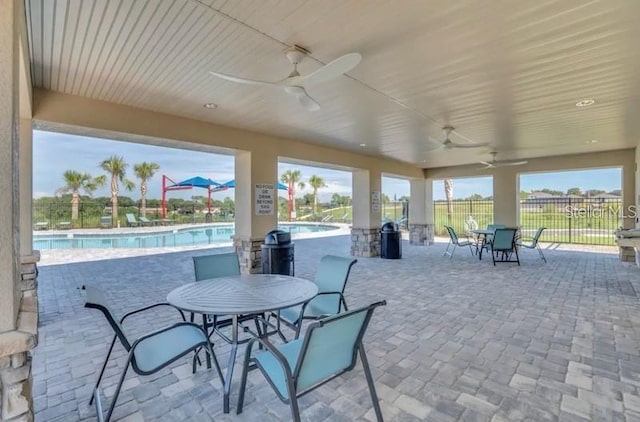 view of patio / terrace with ceiling fan and a community pool