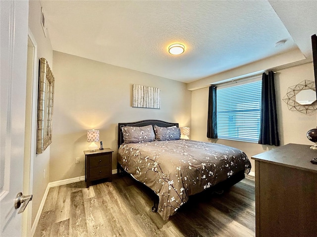 bedroom featuring a textured ceiling and wood-type flooring