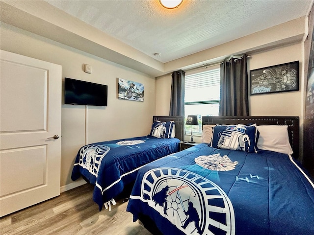 bedroom with wood-type flooring and a textured ceiling