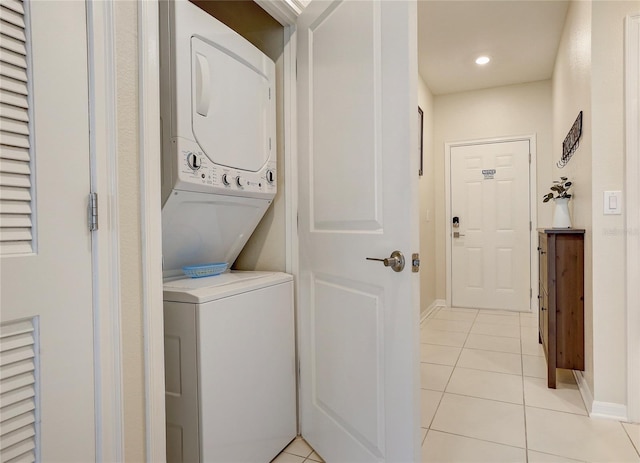 laundry room with light tile patterned floors and stacked washing maching and dryer