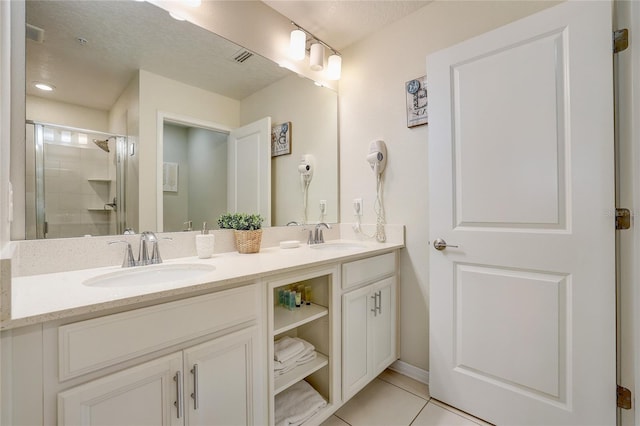 bathroom with tile patterned flooring, a shower with shower door, and vanity