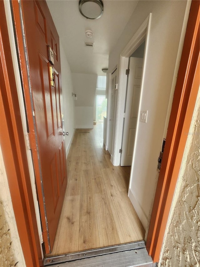 hallway with light hardwood / wood-style flooring