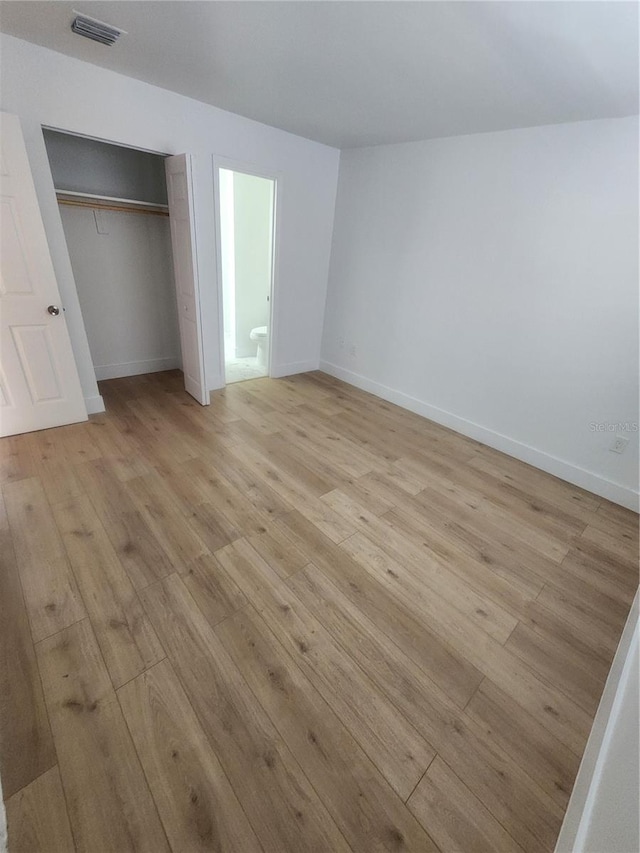 unfurnished bedroom with light wood-type flooring and a closet