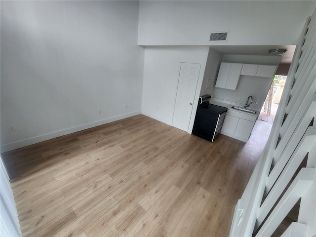 kitchen with sink, white cabinets, and light hardwood / wood-style floors