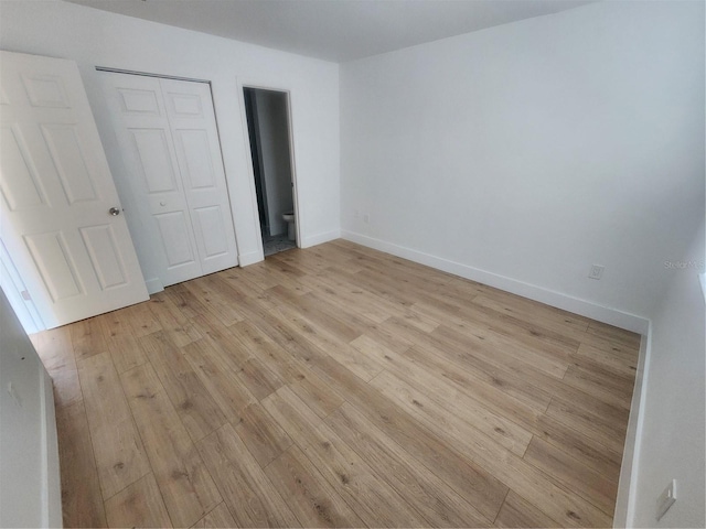 unfurnished bedroom featuring a closet and light wood-type flooring