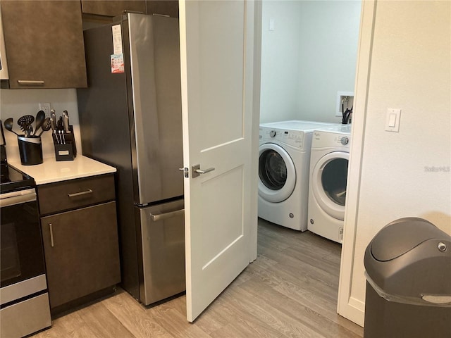 washroom with light hardwood / wood-style flooring and washing machine and clothes dryer