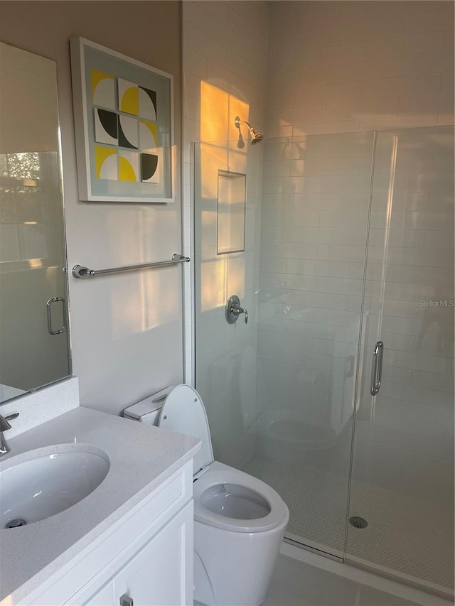 bathroom featuring toilet, vanity, tile patterned flooring, and walk in shower