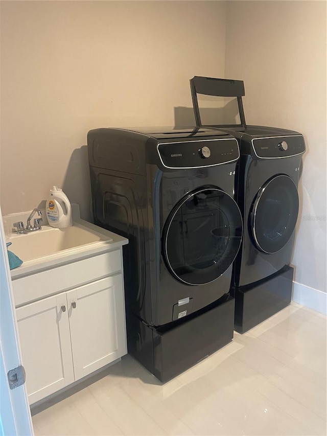 laundry area with cabinets, sink, and washing machine and clothes dryer