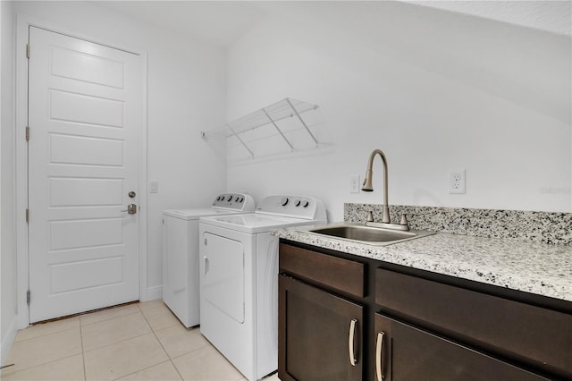 laundry room featuring sink, light tile patterned floors, cabinets, and independent washer and dryer