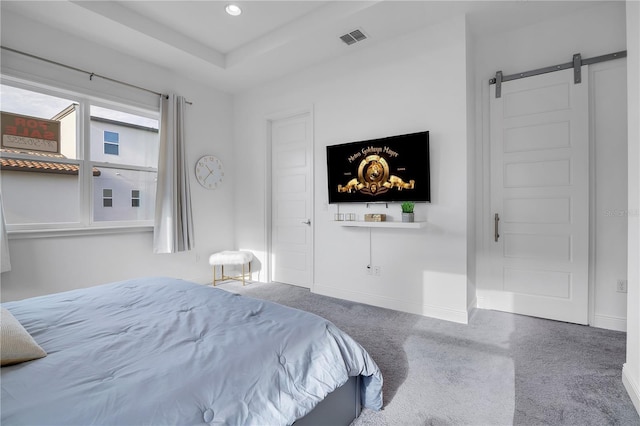 bedroom with a barn door and carpet flooring