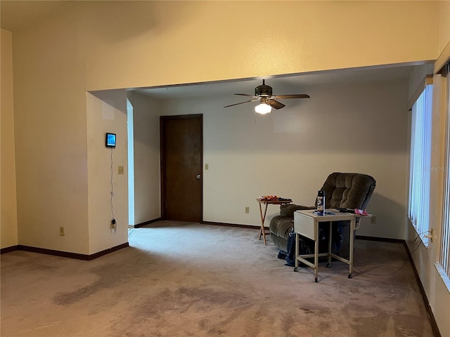 living area with ceiling fan and carpet flooring