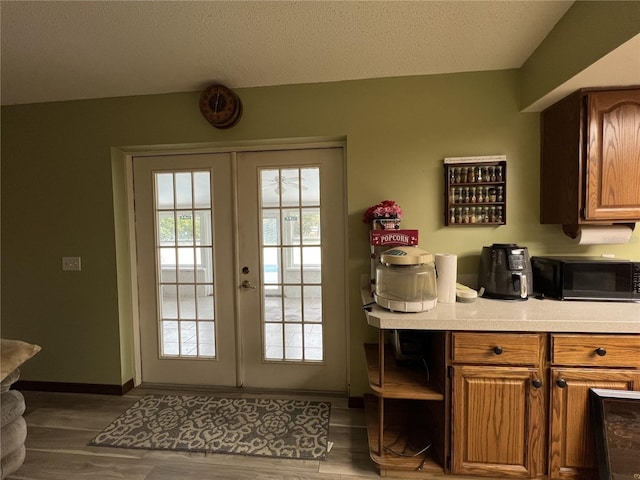 entryway featuring french doors, dark hardwood / wood-style flooring, and a textured ceiling