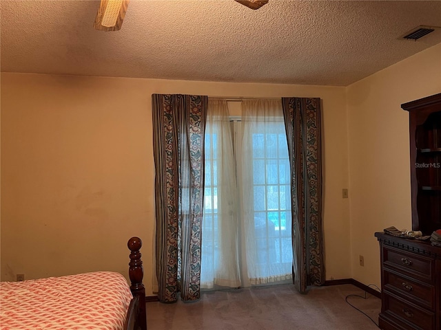 carpeted bedroom with a textured ceiling and ceiling fan