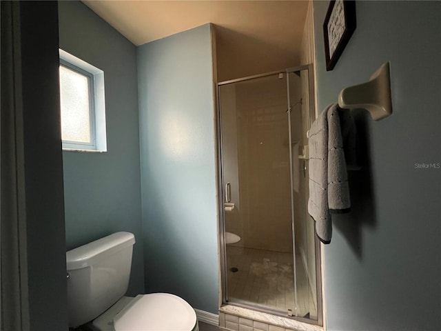 bathroom featuring an enclosed shower and toilet