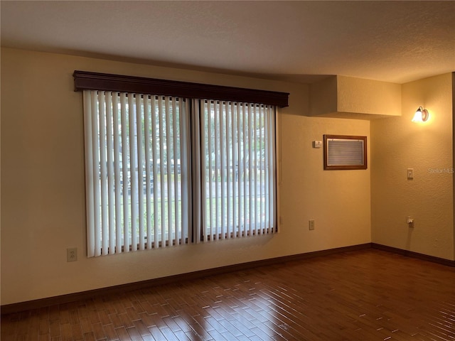 unfurnished room featuring dark hardwood / wood-style flooring and a healthy amount of sunlight