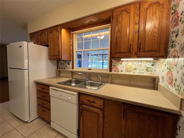 kitchen featuring backsplash, sink, white appliances, and light tile patterned flooring