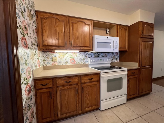 kitchen with light tile patterned floors and white appliances