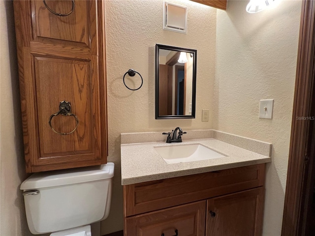 bathroom featuring toilet and vanity