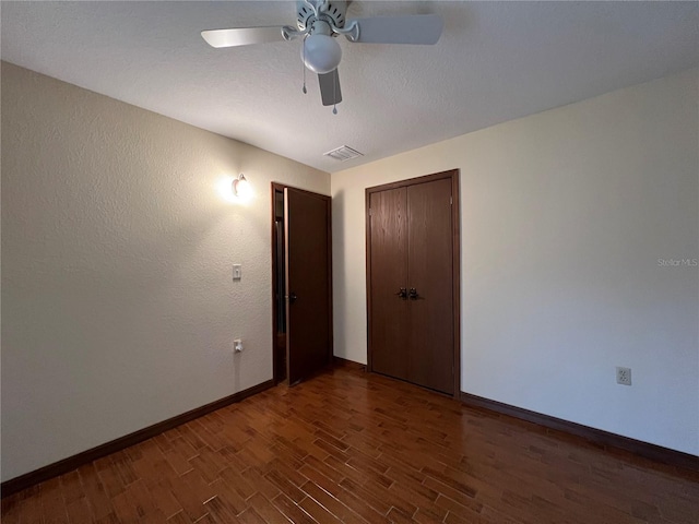 empty room featuring dark wood-type flooring and ceiling fan