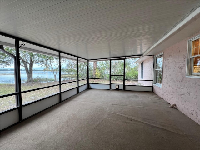 unfurnished sunroom featuring a water view