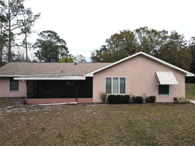 rear view of house with a yard and a sunroom