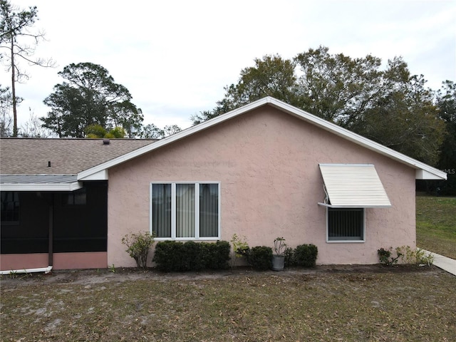 view of property exterior with a sunroom and a yard