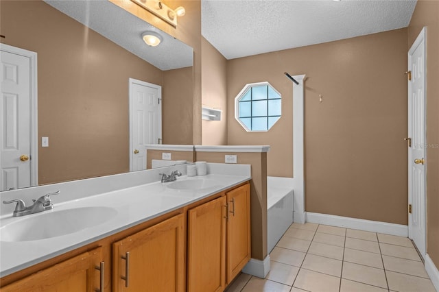 bathroom with tile patterned floors, vanity, a textured ceiling, and a tub