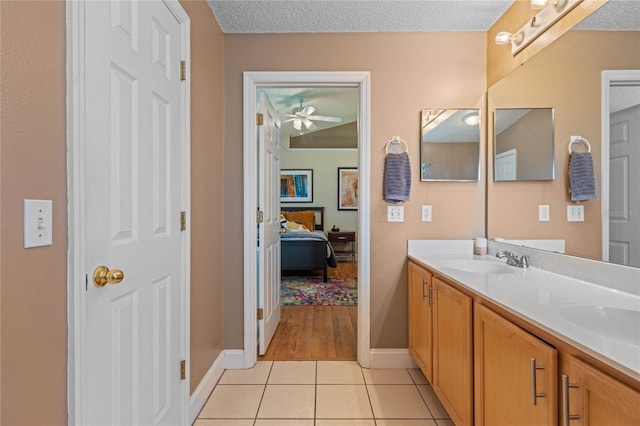 bathroom with ceiling fan, tile patterned floors, a textured ceiling, and vanity