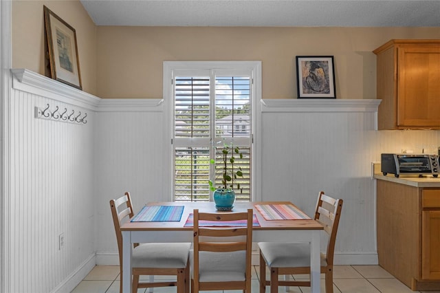 dining area with light tile patterned floors and a textured ceiling